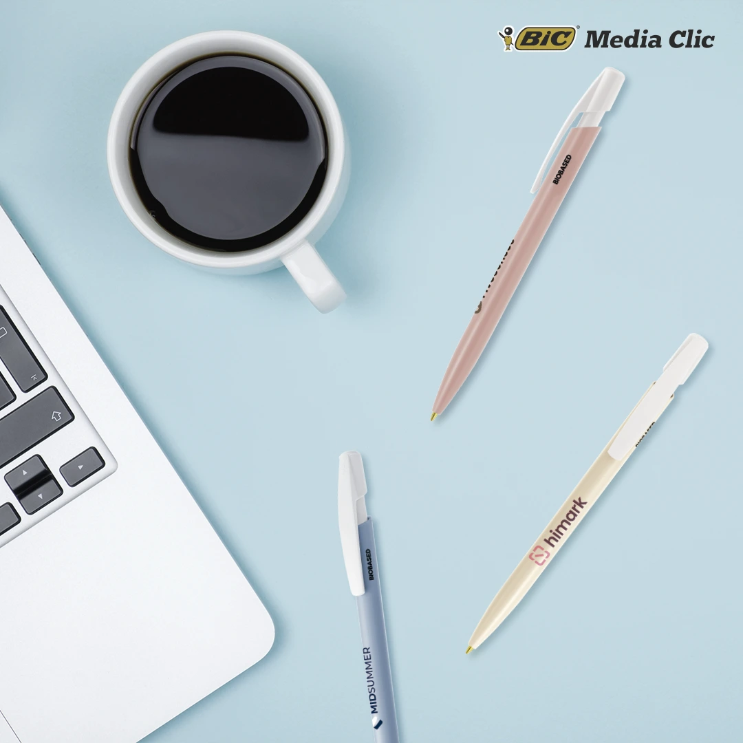 Stylos BIC Media Clic personnalisés disposés sur un bureau avec ordinateur et tasse de café